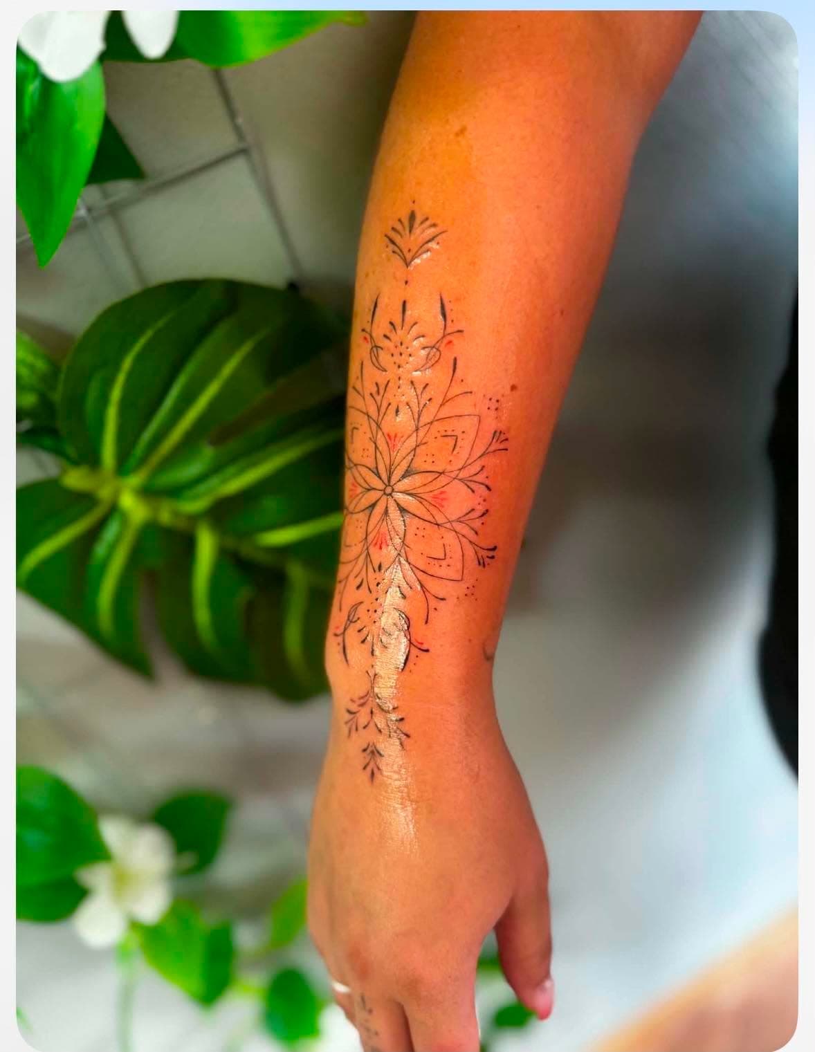 Tatouage fine line ornemental : motif floral mandala sur l’avant-bras